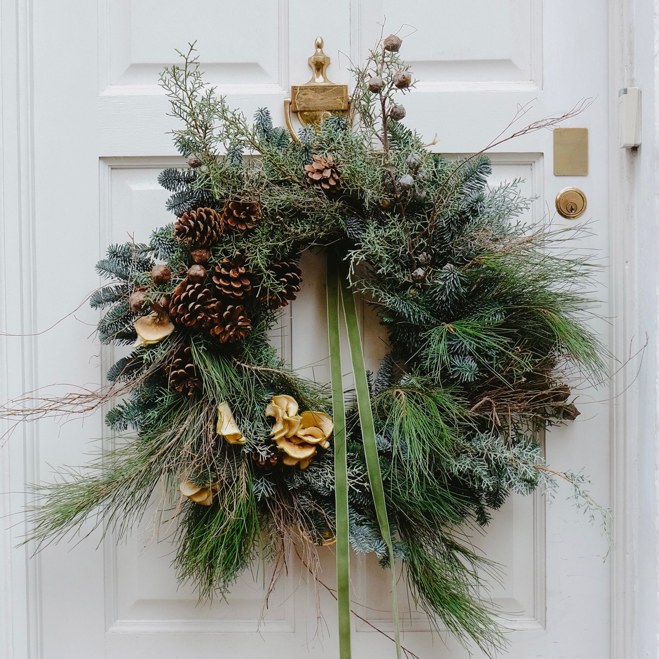 festive Christmas wreath to buy online for delivery in London and UK. Made with pine cones and festive foliage