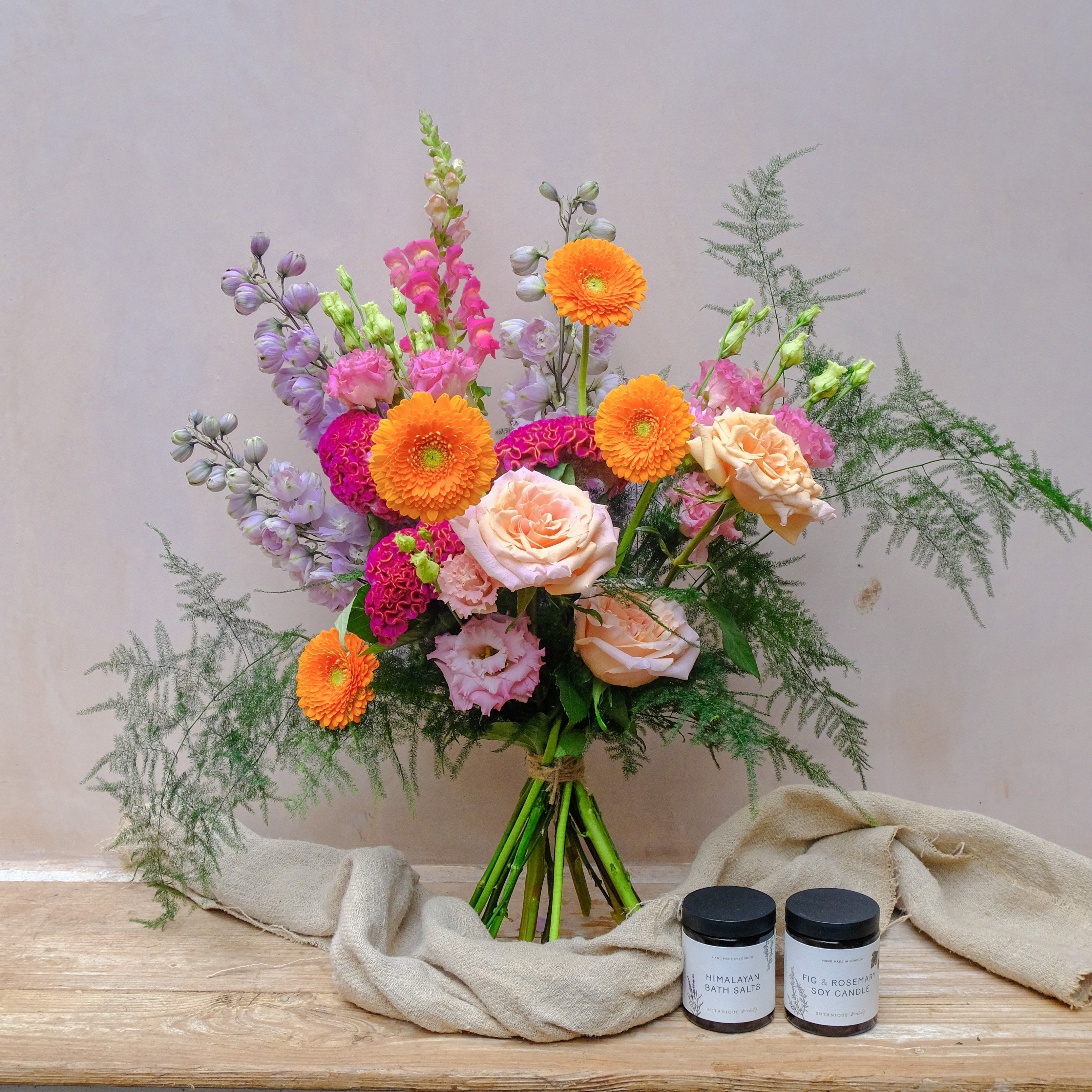 colourful fresh flowers bouquet with candle and bath salts as gift set