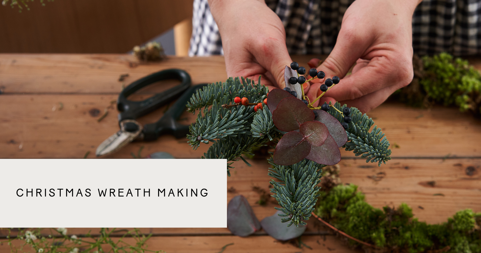 someone making a christmas wreath at a Botanique wreath making workshop in london