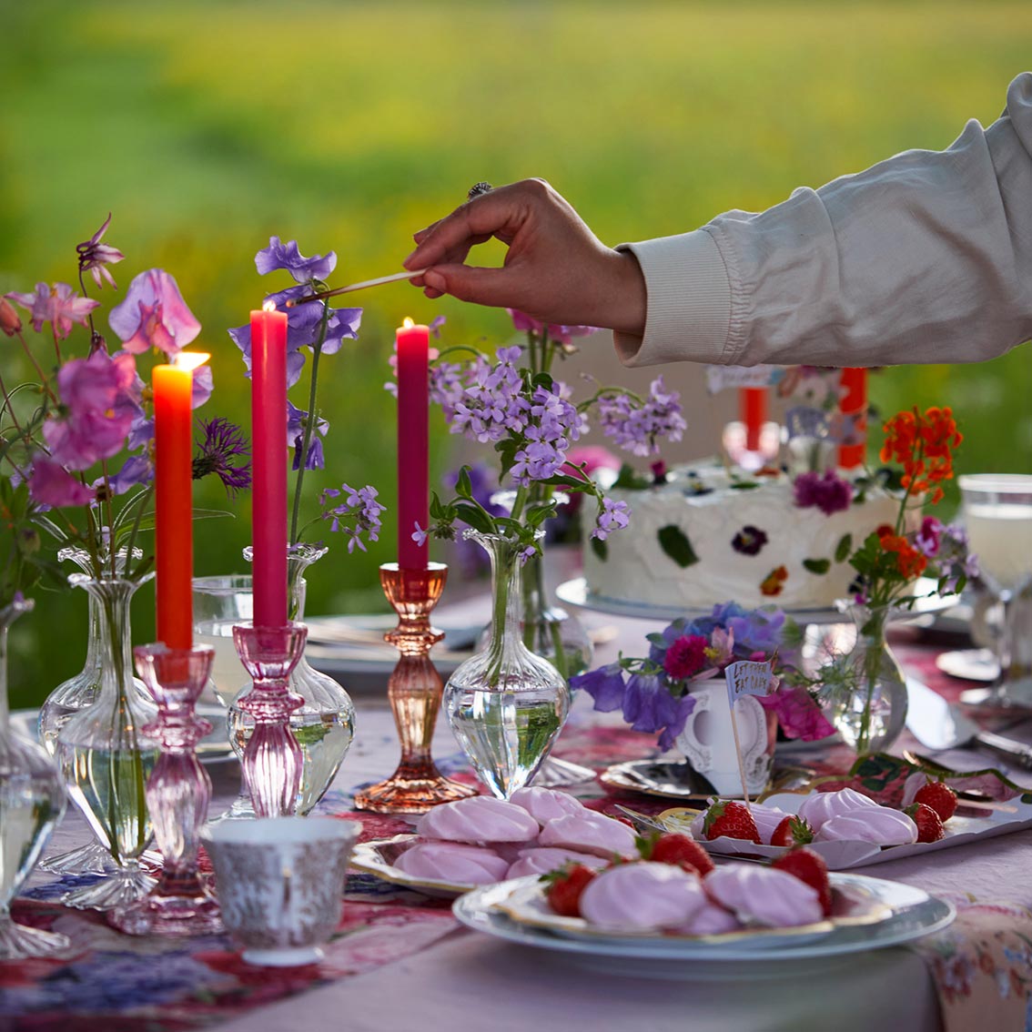 glass bud vases and colourful candle holders on table