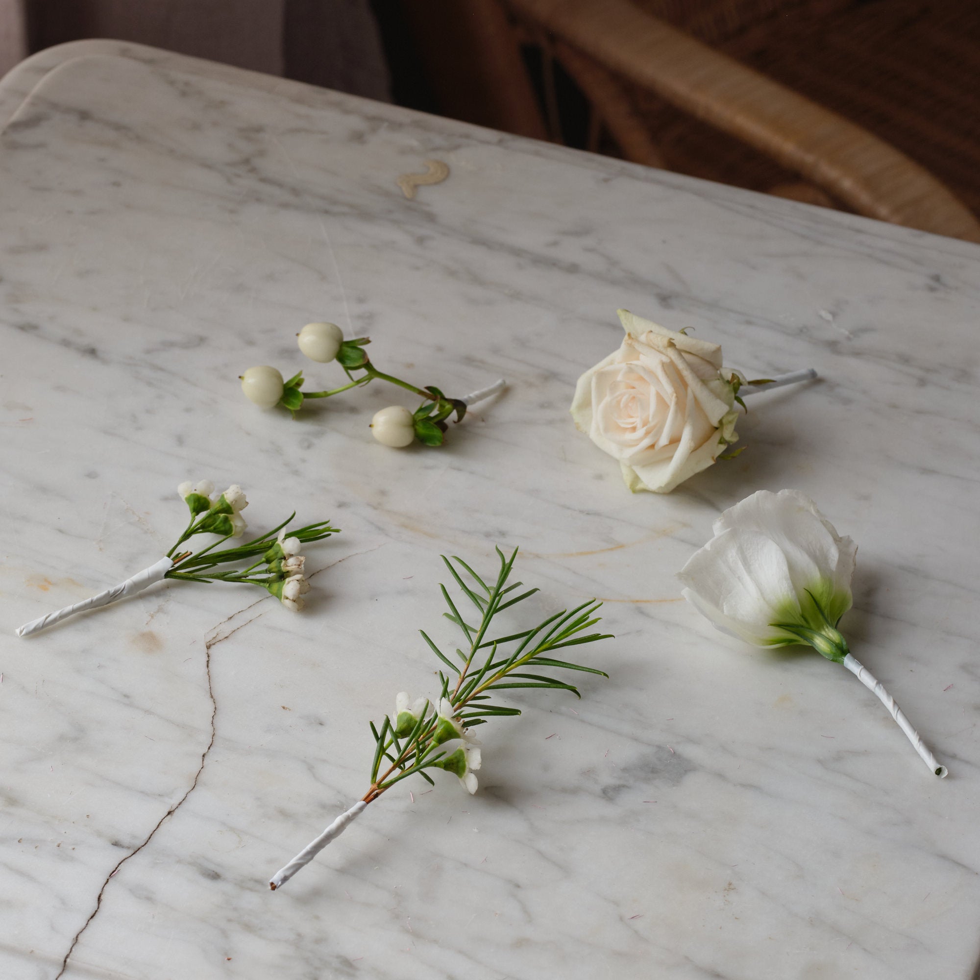 classic white hair sprigs made with seasonal white and off-white flowers roses and fresh foliage