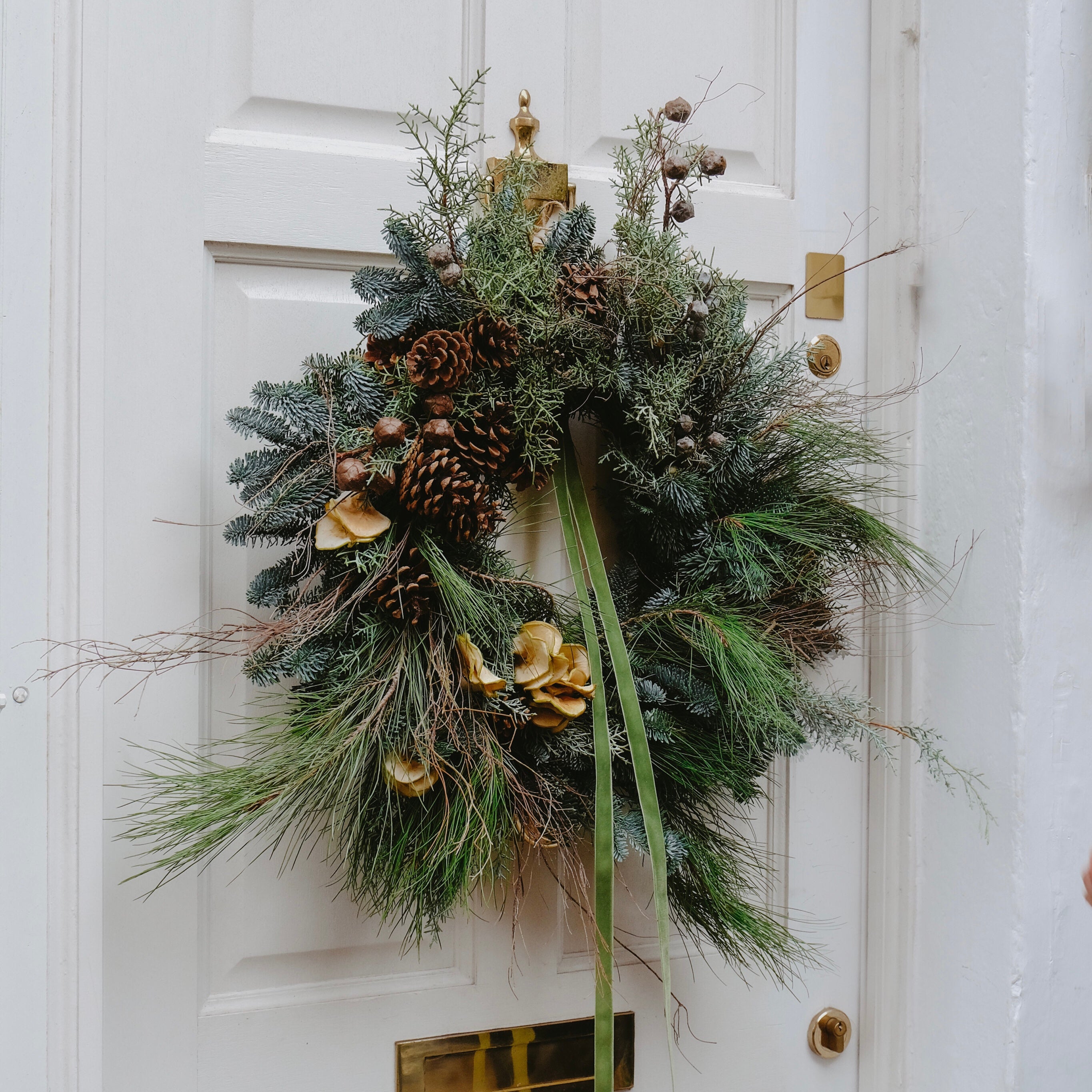 festive Christmas wreath to buy online for delivery in London and UK. Made with pine cones and festive foliage