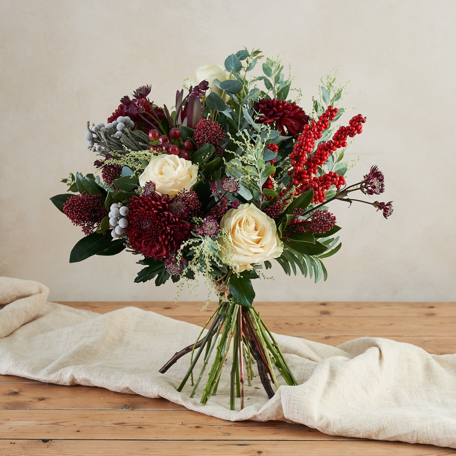 Noel Christmas bouquet with burgundy flowers, white roses and berries