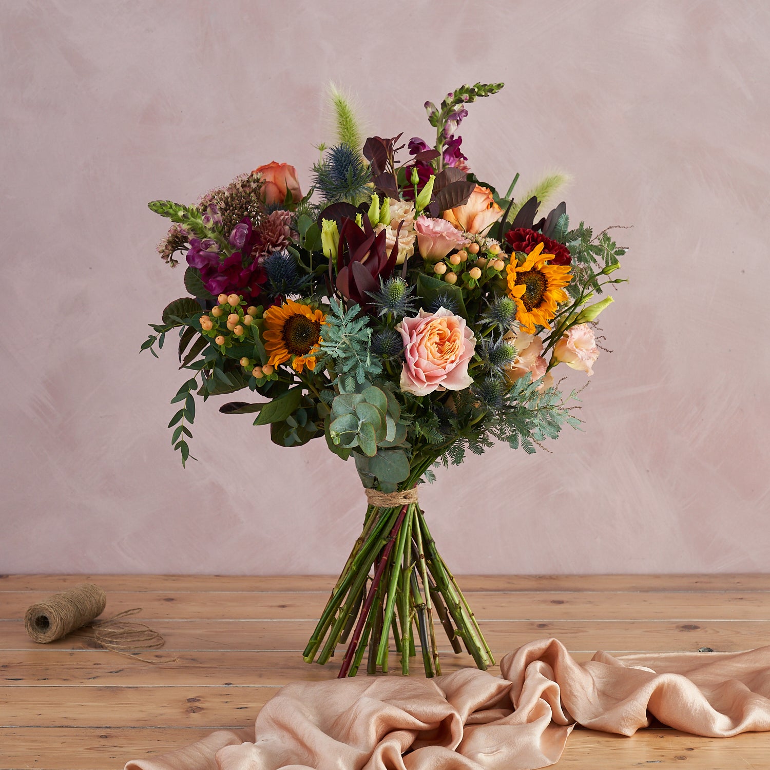 autumn fresh flowers bouquet with sunflowers, garden roses and thistles