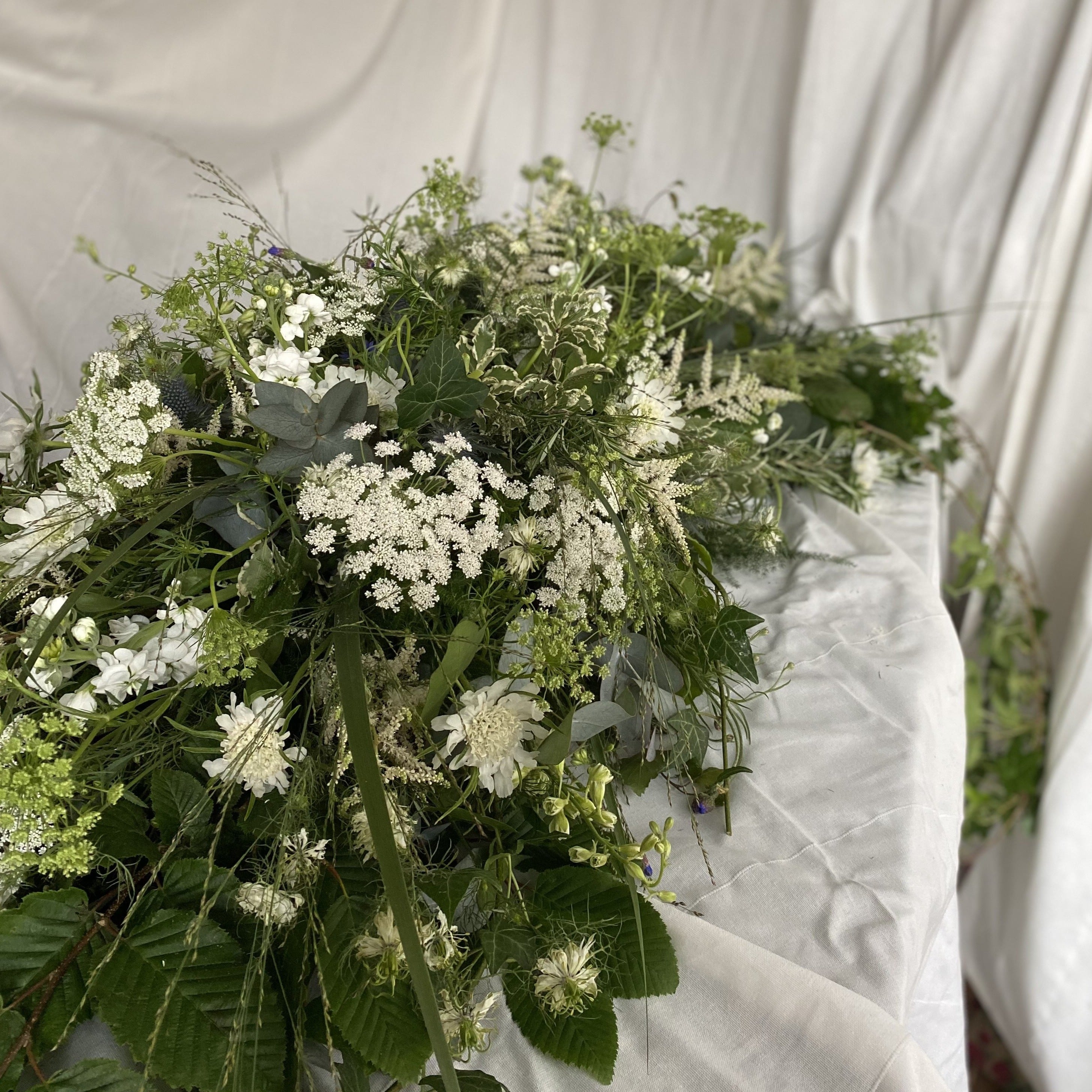 Whimsical white funeral coffin spray