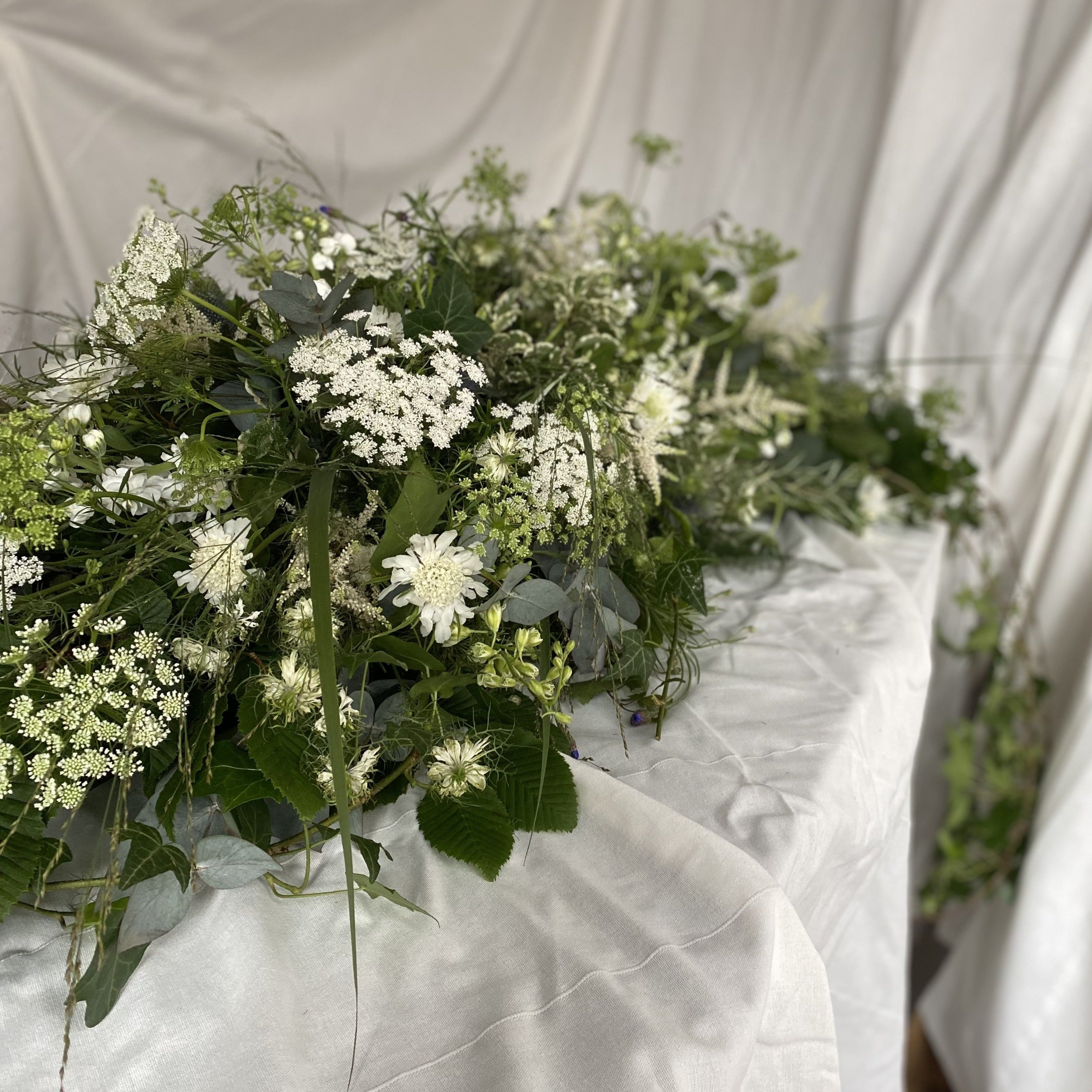 Whimsical white funeral coffin spray