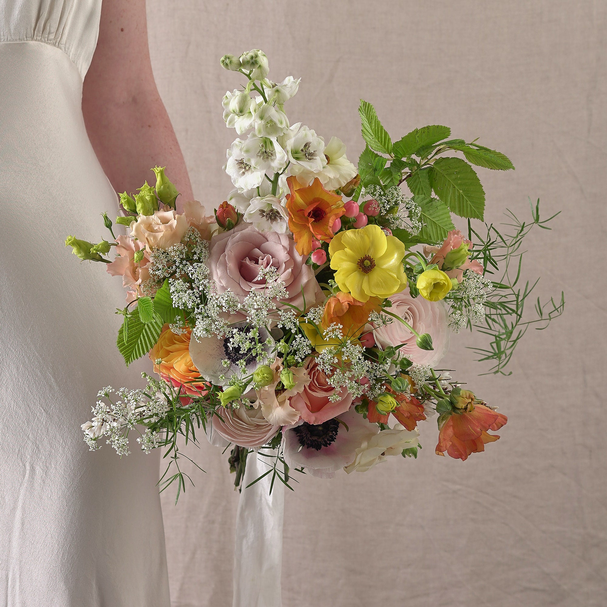 vibrant summery and colourful bridal bouquet with yellow green white and coral flowers by Botanique Workshop London