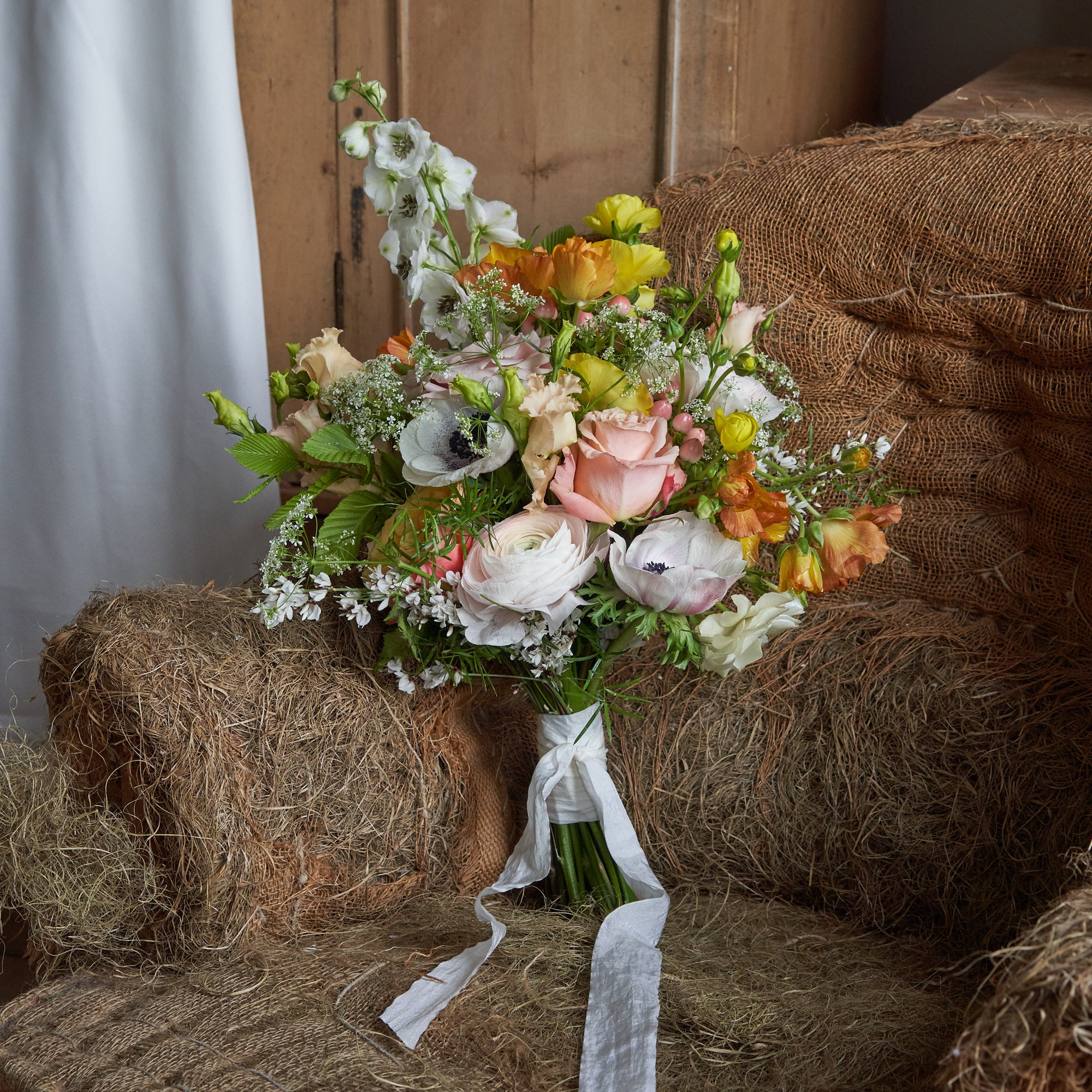 vibrant summery and colourful bridal bouquet with yellow green white and coral flowers by Botanique Workshop London