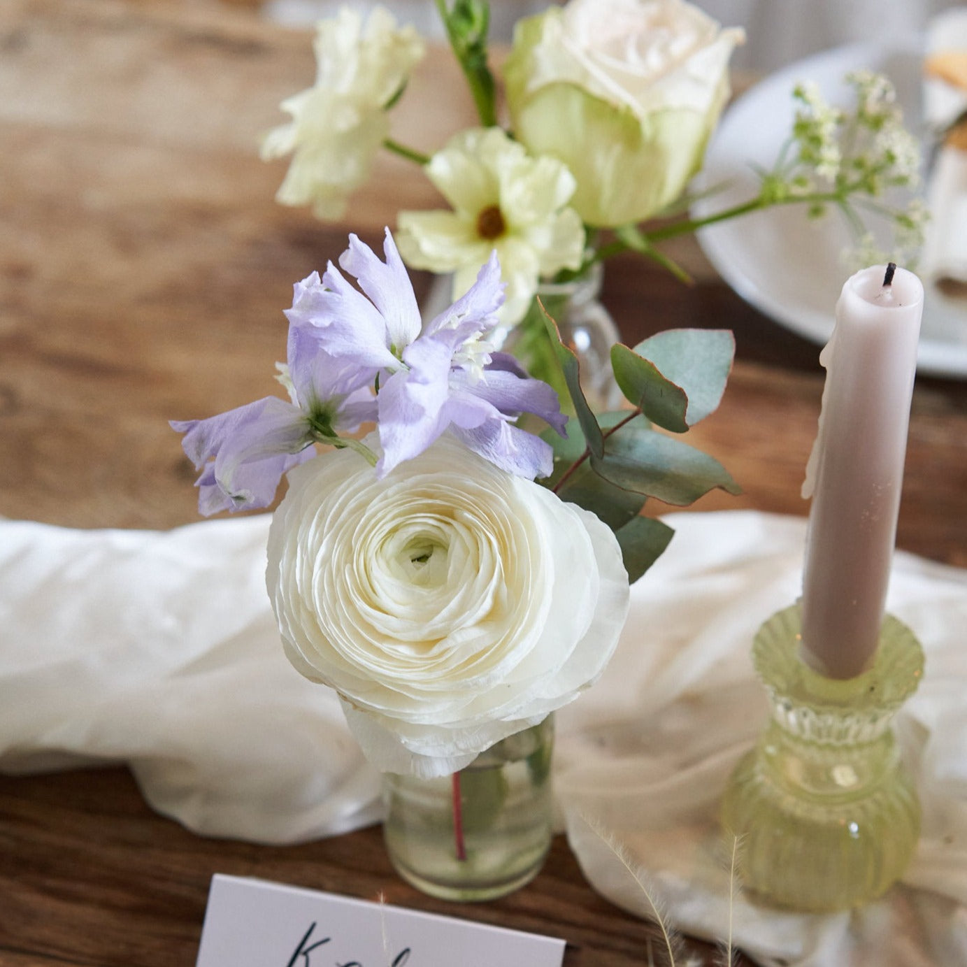 pastel wildflowers in milk bottles to decorate wedding venue and dining table