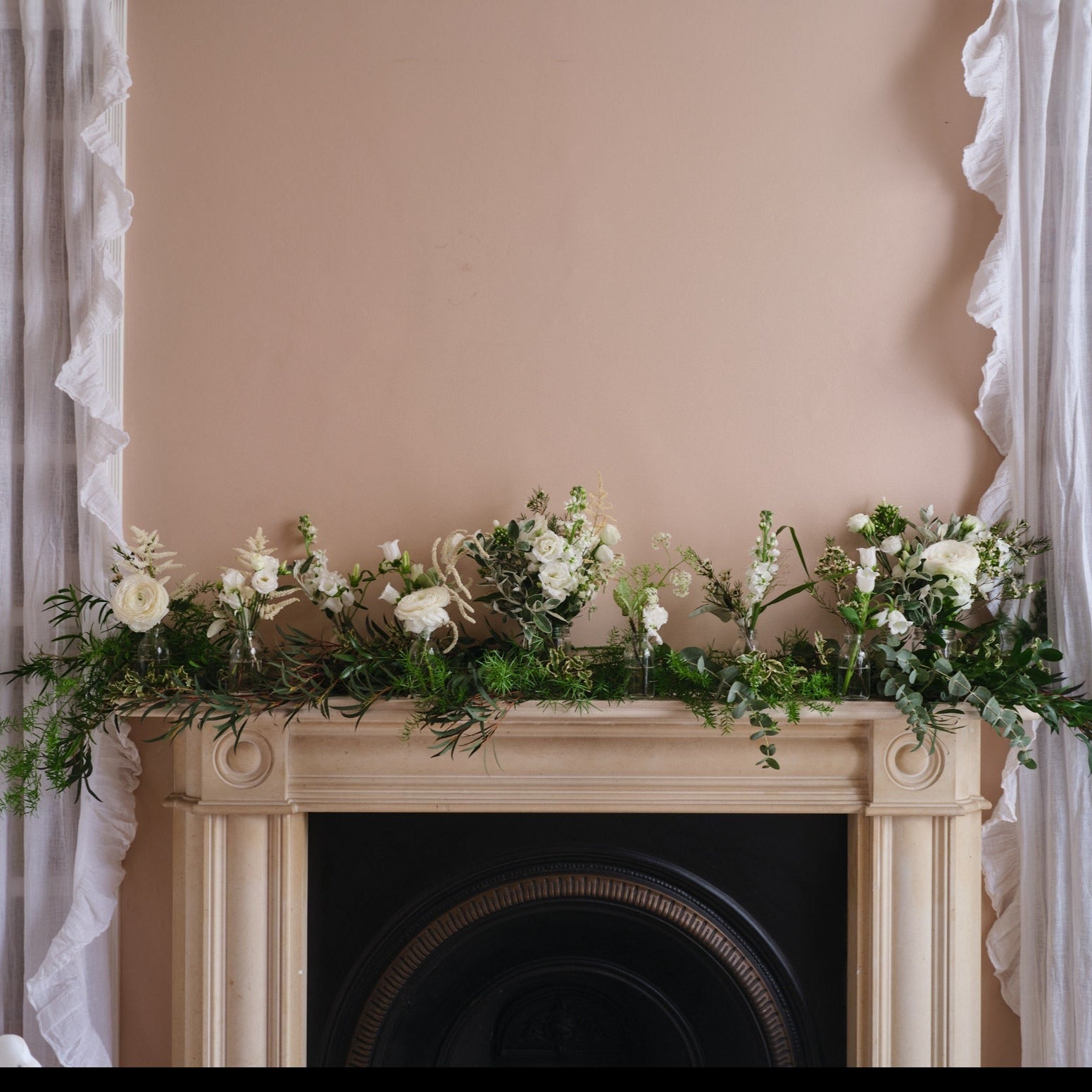 white and green wedding mantlepiece decorations with seasonal flowers and green foliage