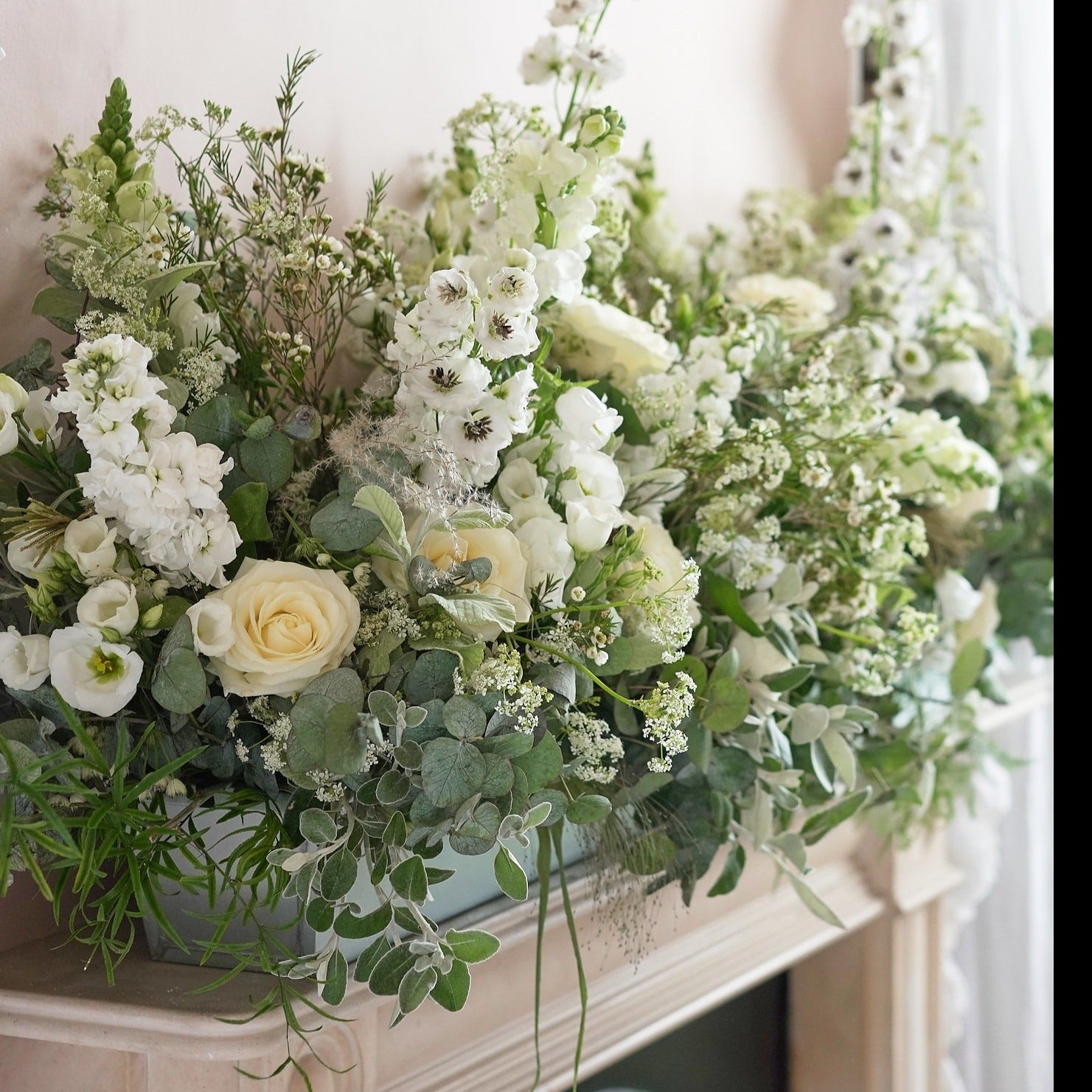 classic white and green foliage trough arrangement to decorate wedding venues and mantlepieces