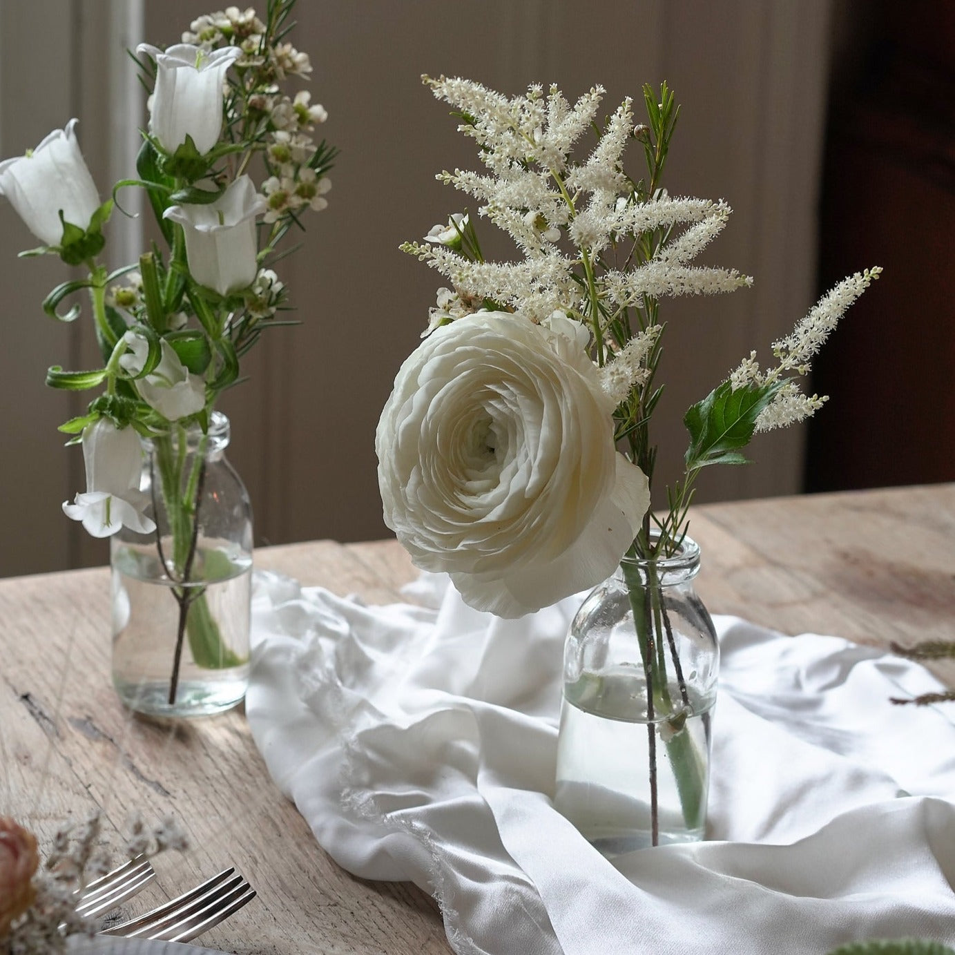 white and green wedding table decorations with seasonal flowers and green foliage