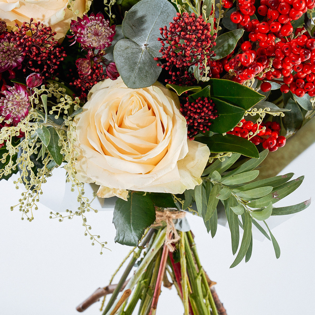 Noel Christmas bouquet with burgundy flowers, white roses and berries