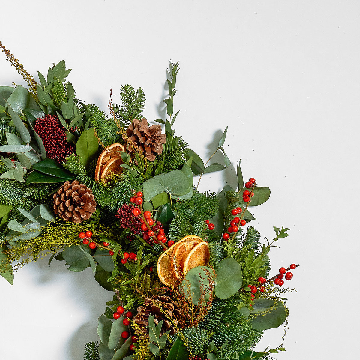 christmas wreath classic design with pine cones, dried oranges and berries by Botanique Workshop London